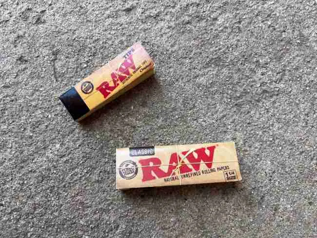 RAW branded rolling papers and filter tips on a concrete surface
