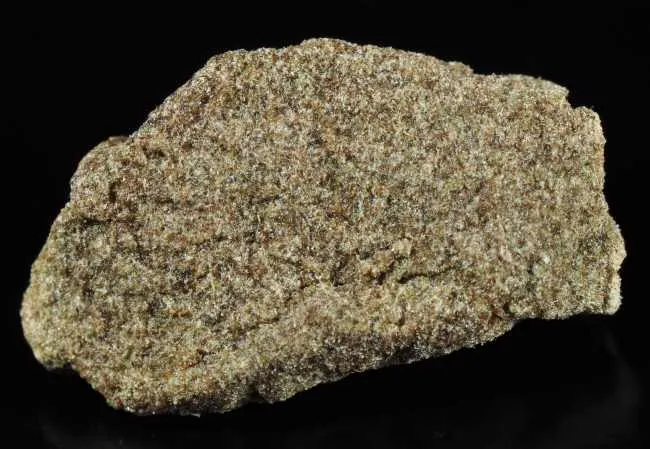 close up image of green and brown brick of bubble hash